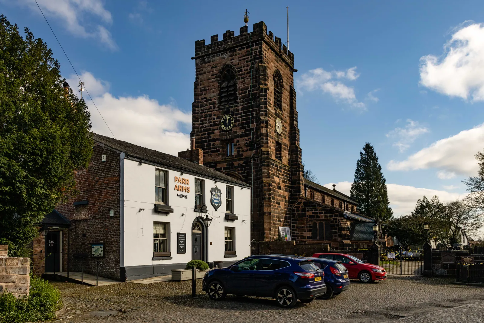 St Wilfrid’s Church and the Parr Arms in Grappenhall village beneath a blue sky